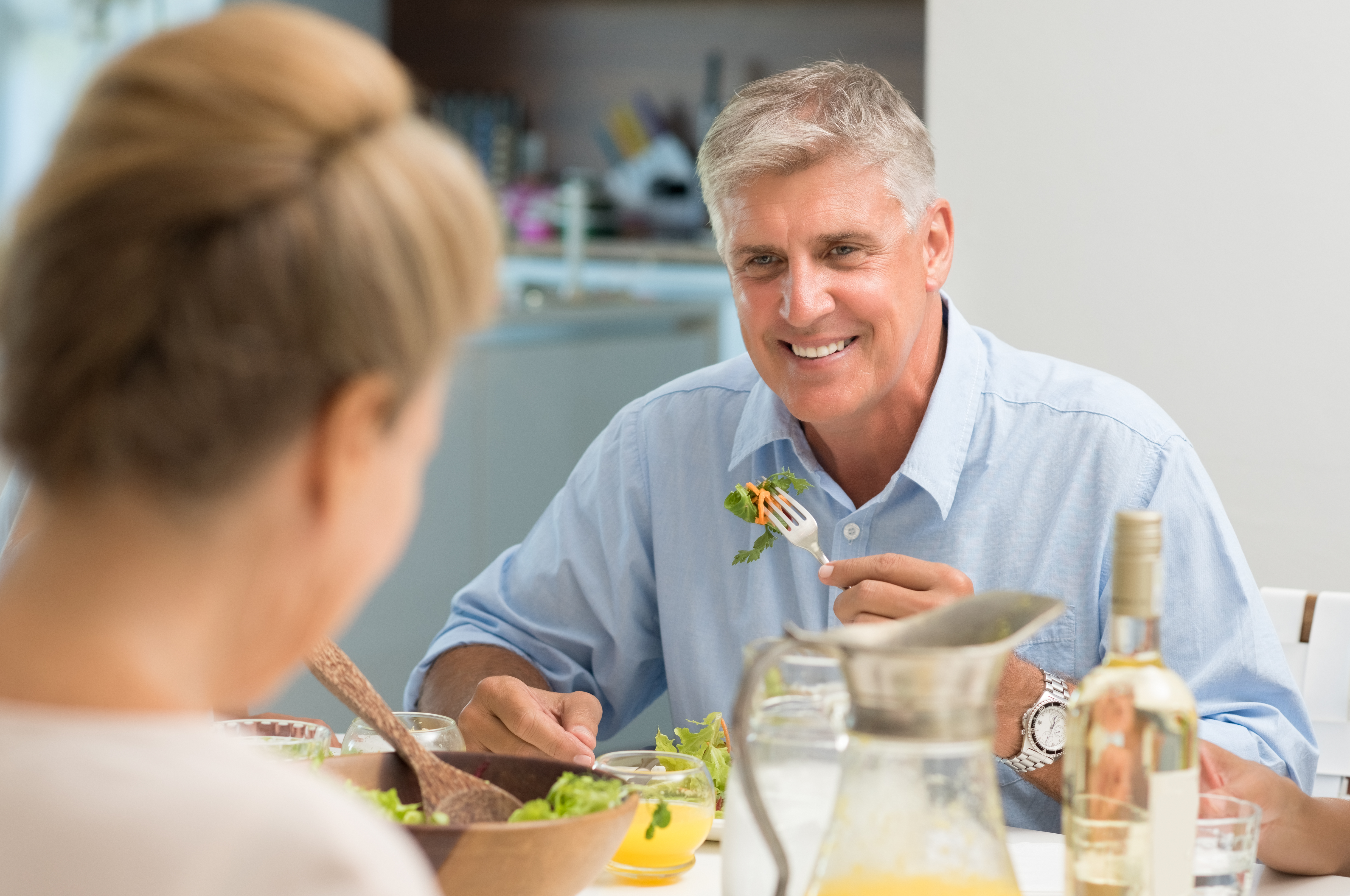 Older man eating and smiling