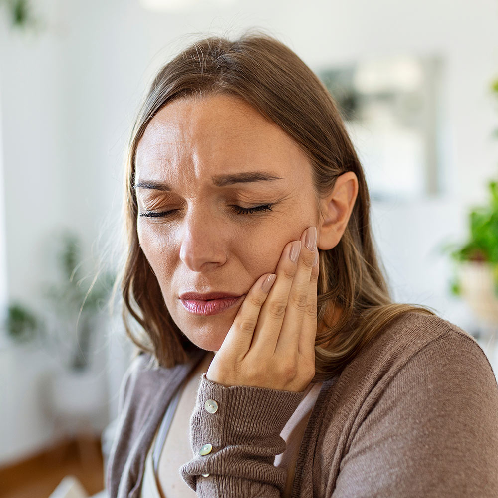 Woman holding jaw in pain
